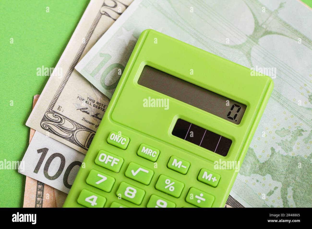 Verantwortungsvolle Kreditvergabe. Grüner Taschenrechner, Dollar, Geld auf grünem Hintergrund. Null-Verschwendung-Konzept Stockfoto