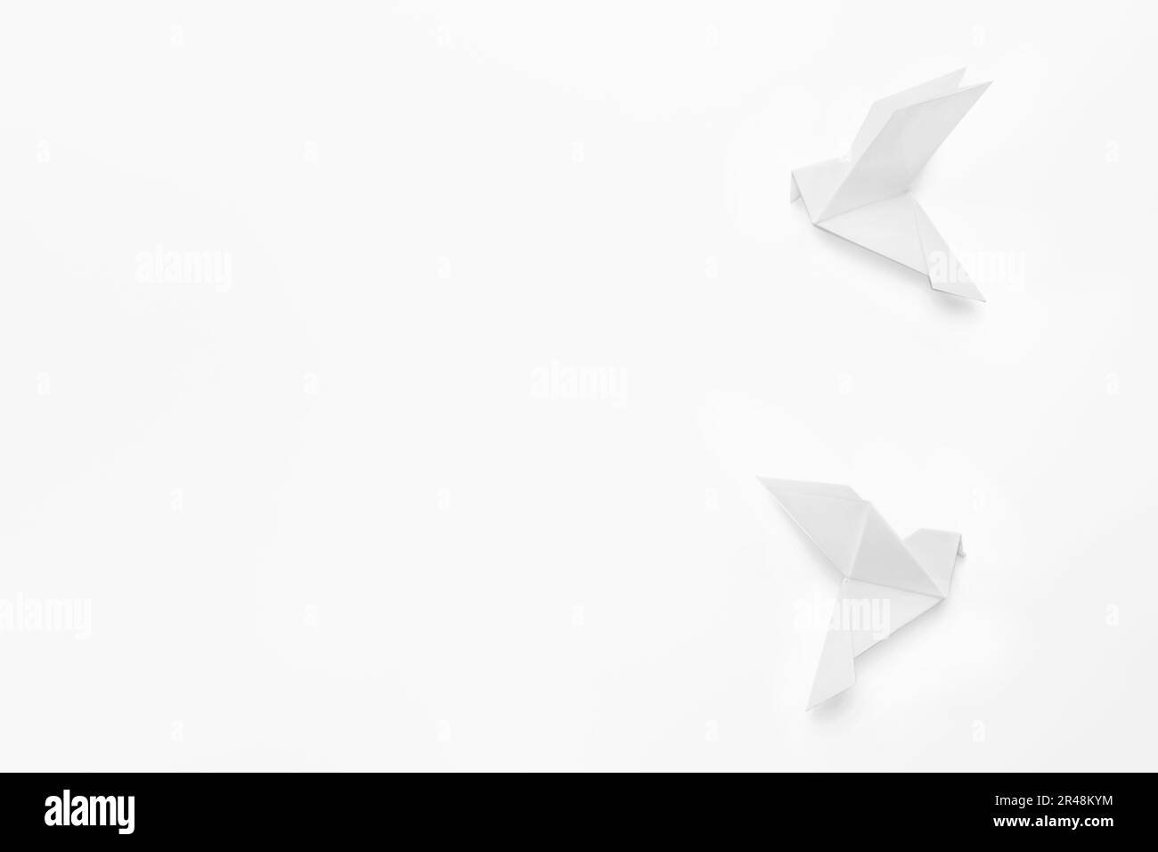 Wunderschöne Origami-Vögel auf weißem Hintergrund, flach liegend. Platz für Text Stockfoto