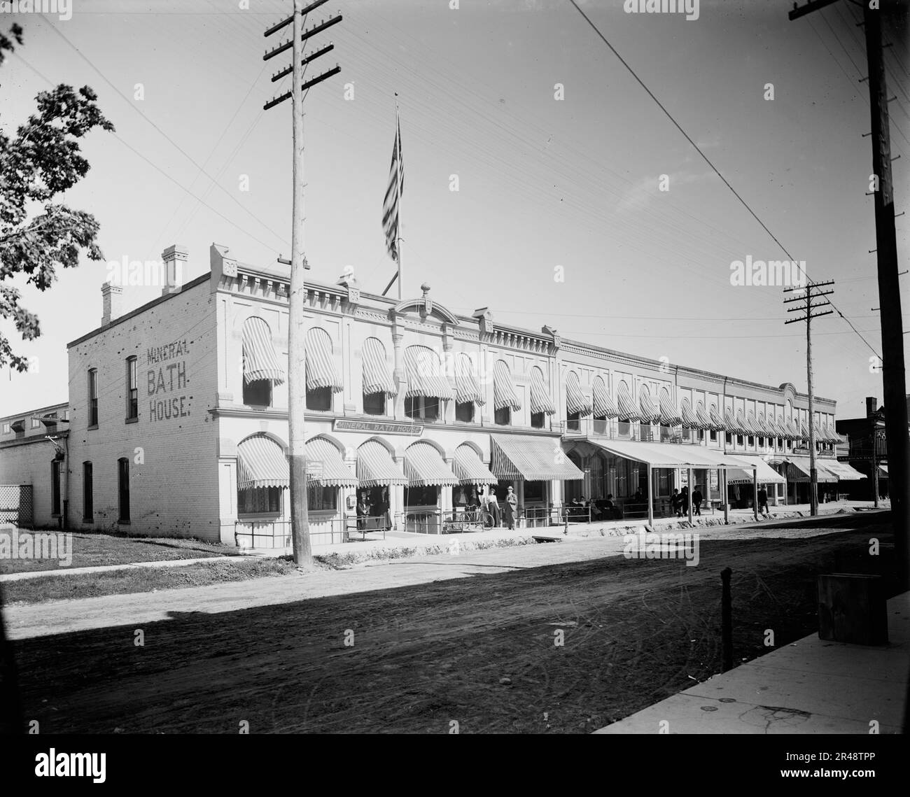 Gewerbeblock mit Mineralbadehaus auf der linken Seite, wahrscheinlich Ypsilanti, Michigan, zwischen 1900 und 1910. Stockfoto