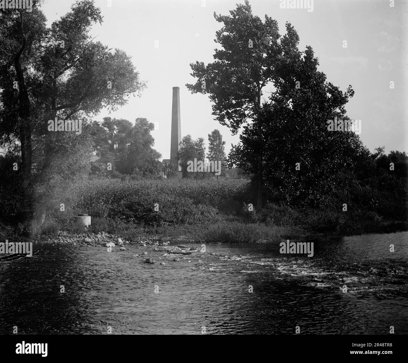 Schornstein am Fluss, wahrscheinlich der Huron River, Ypsilanti, Michigan, zwischen 1900 und 1910. Stockfoto