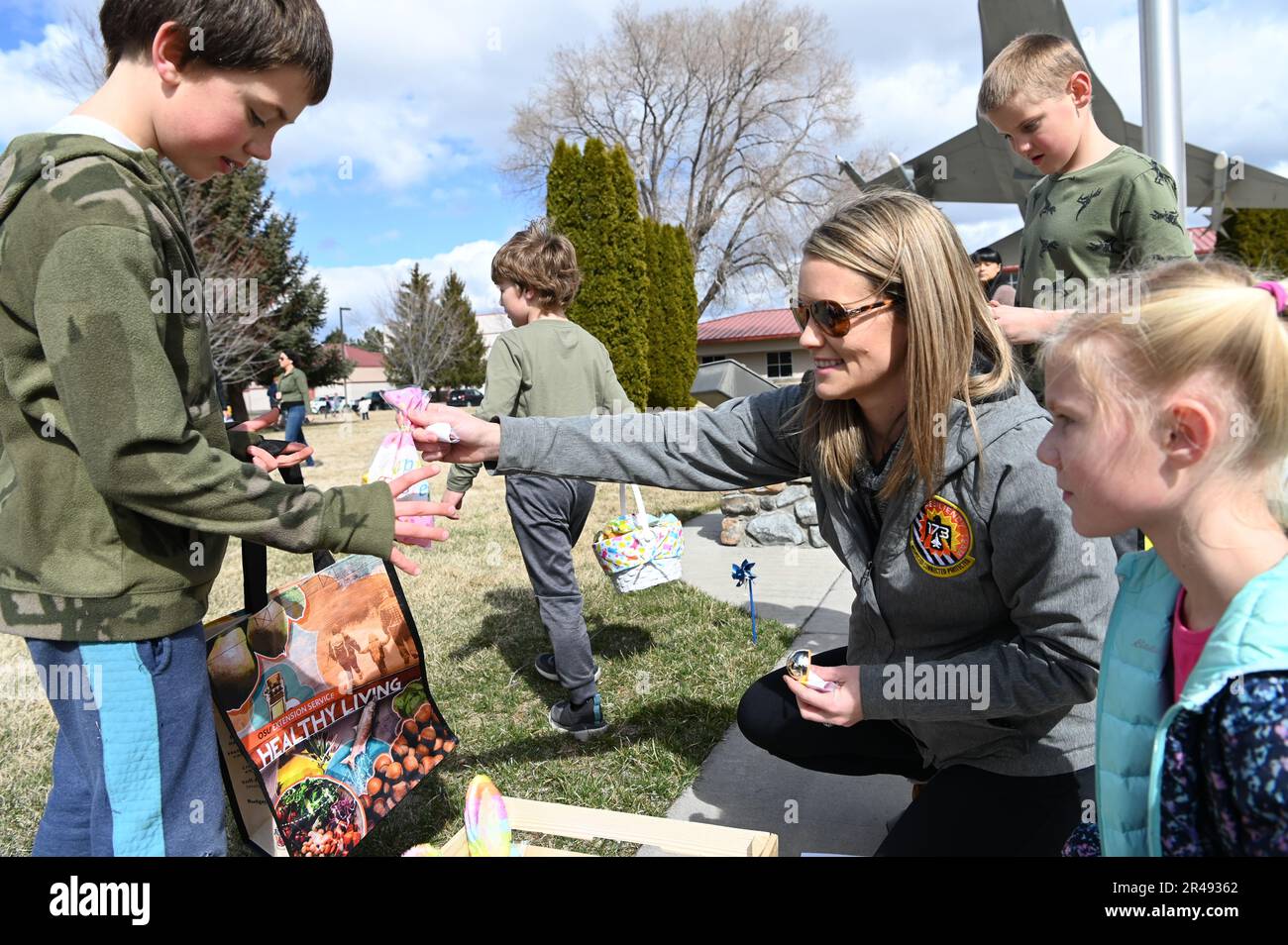 Ein kleiner Junge gibt sein goldenes Ei für einen Preis an Cecily Gaudinski, 173. Fighter Wing Military and Family Readiness Coordinator, bei der Kingsley Field Eiersuche am 07. April 2023 im Kingsley Field in Klamath Falls, Oregon. Das Military and Family Readiness Team war Gastgeber der jährlichen Eierjagd für die Kinder der Basismitglieder zu Ehren des Aprilmonats des Militärkindes. Stockfoto