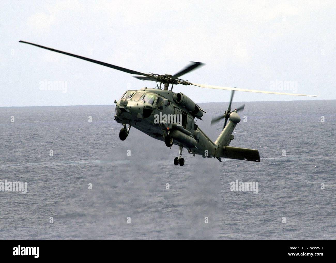 US Navy ein HH-60H Seahawk bereitet sich darauf vor, neben Constellation zu schweben, um seine Fähigkeit zu demonstrieren, sehr tief ins Wasser zu fliegen Stockfoto