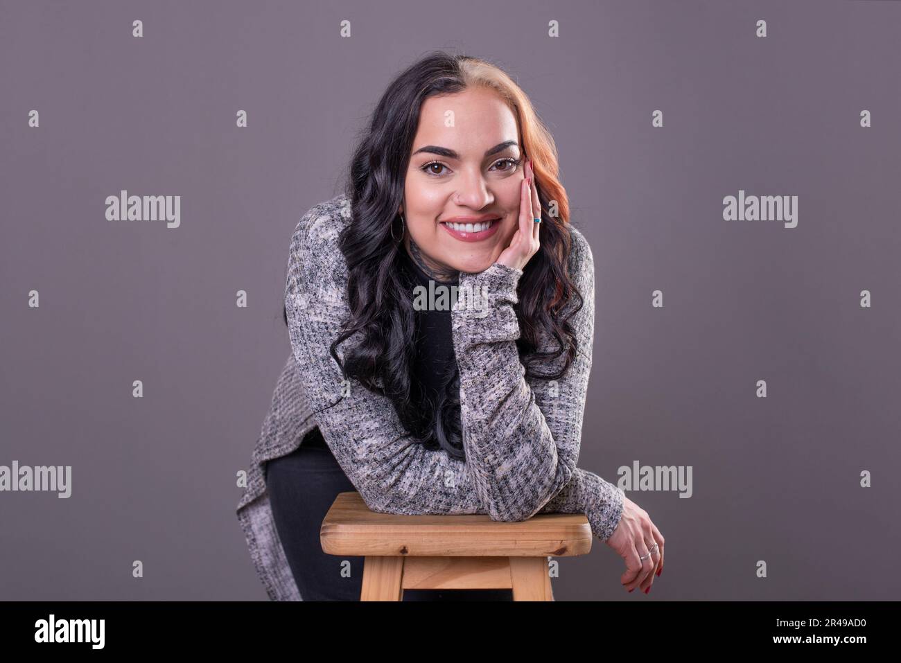 Eine schöne Frau, die in die Kamera schaut, mit den Händen im Gesicht. Studioaufnahme Stockfoto