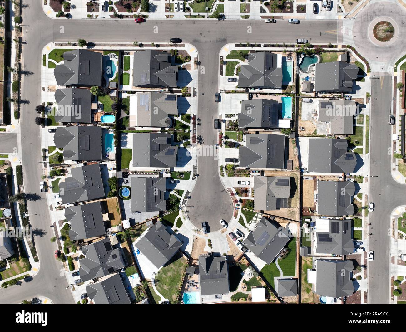 Luftaufnahme einer Wohngegend in den Vororten mit einer gepflasterten Straße, die sich durch die Nachbarschaft schlängelt Stockfoto
