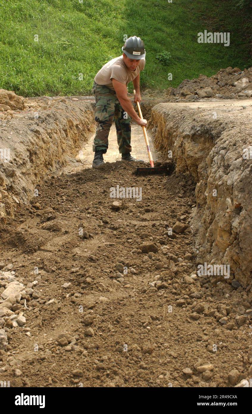 DER BAUMEISTER Romen Deleon von DER US Navy baut Erde auf einem Fundament auf, bevor Beton gegossen wird Stockfoto