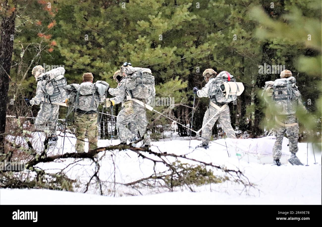 Am 18. Januar 2023 erlernen Luftwaffe mit mehreren Air National Guard- und Air Force Reserve-Sicherheitseinheiten Truppentaktik beim Ziehen eines Ahkio-Schlittens im Rahmen eines 16-tägigen Kurses über Operationen bei kaltem Wetter, der von der Air Force in Fort McCoy, Wisconsin, geleitet wird. Mehr als 50 Flugzeuge nehmen an dem Training aus der gesamten Luftwaffe Teil. Neben dem Wissen über die Verwendung von Schneeschuhen und das Bewegen als Truppe über das Gelände, das einen Ahkio-Schlitten in einer Umgebung mit kaltem Wetter zieht, erfuhren die Airmen auch etwas über Unterstände bei kaltem Wetter, Überlebenstechniken, Kleidung für kaltes Wetter und vieles mehr. Fort McCoy hat eine lange Geschichte als Unterstützer von Col Stockfoto