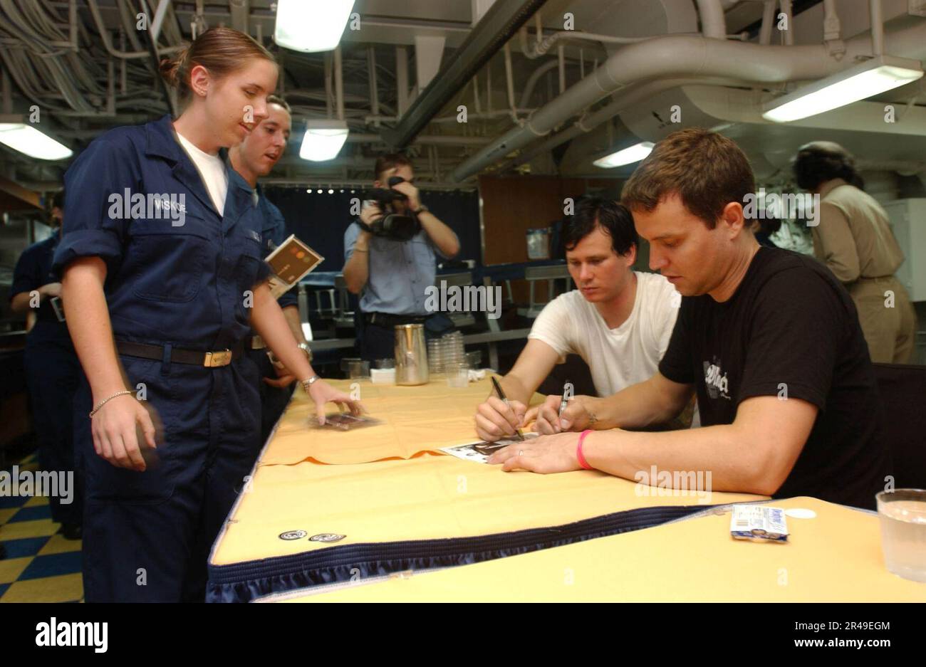 US Navy The Rock Bank Blink-182 Singer, Bass-Gitarrist Mark Hoppus und Sänger, Gitarrist Tom DeLonge, signieren Autogramme vor einer Show der United Services Organization (USO) an Bord der USS Nimitz Stockfoto