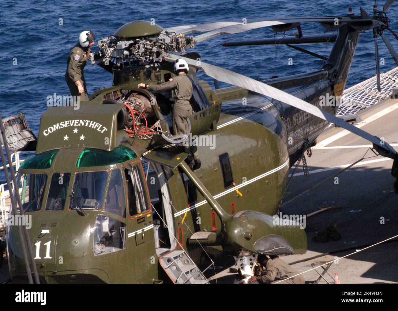 US Navy Airmen, die den Kriegsherren des leichten Hubschraubers zugeteilt sind Anti-U-Boot-Geschwader 51 (HSL-51), führen Wartungsarbeiten am Kommandanten durch, Hubschrauber der siebten Flotte an Bord der USS Blue Ridge (LCC 19) Stockfoto