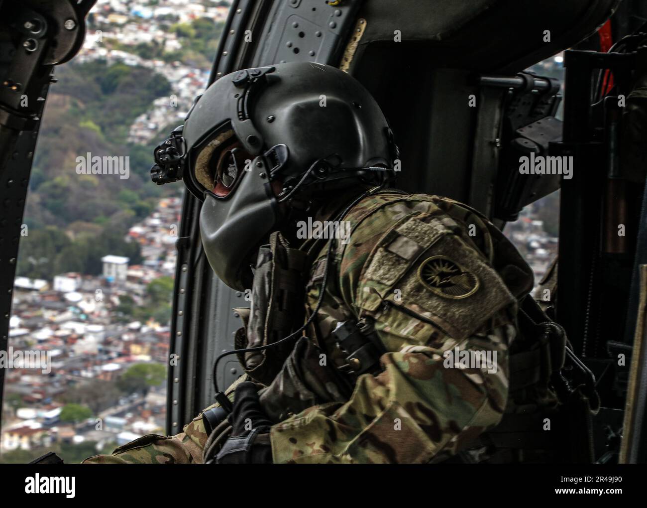 Sgt. Xavier Martinez, ein UH60 Crew Chief vom 1-228. Aviation Regiment, überwacht seinen UH60 Blackhawk während ihres Rückflugs, nachdem die Guatemala Naval Special Forces am 21. März 2023 WÄHREND CENTAM Guardian 23 in San Jose, Guatemala, POMMES Training mit den Navy Seals durchgeführt hatten. CG23 ist eine jährliche, von der Armee geführte, gemeinsame, interinstitutionelle, multinationale Partnerschaftsübung zum Aufbau von Kapazitäten, Fähigkeiten und Interoperabilität mit den zentralamerikanischen Partnerländern. Stockfoto