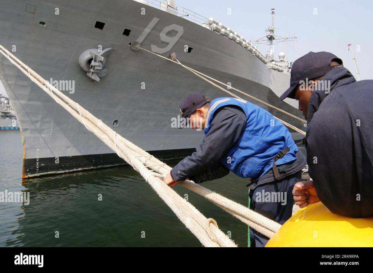 DIE US Navy unter dem wachsamen Auge von Boatswain's Mate Seaman zieht die frap- und Wrap-Linie an doppelten Anlegestellen zusammen. Stockfoto