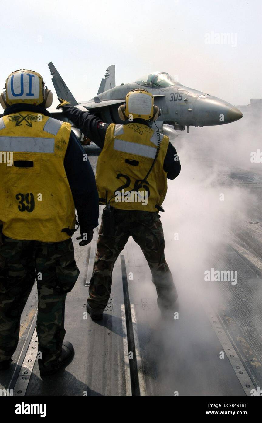 US Navy ein F-A-18C Hornet, das dem Golden Dragons of Strike Fighter Squadron One Nine Two (VFA-192) zugeteilt wurde, wird auf ein Katapult gerichtet, um sich auf den Start vom Flugdeck an Bord der USS Kitty Hawk (CV Stockfoto