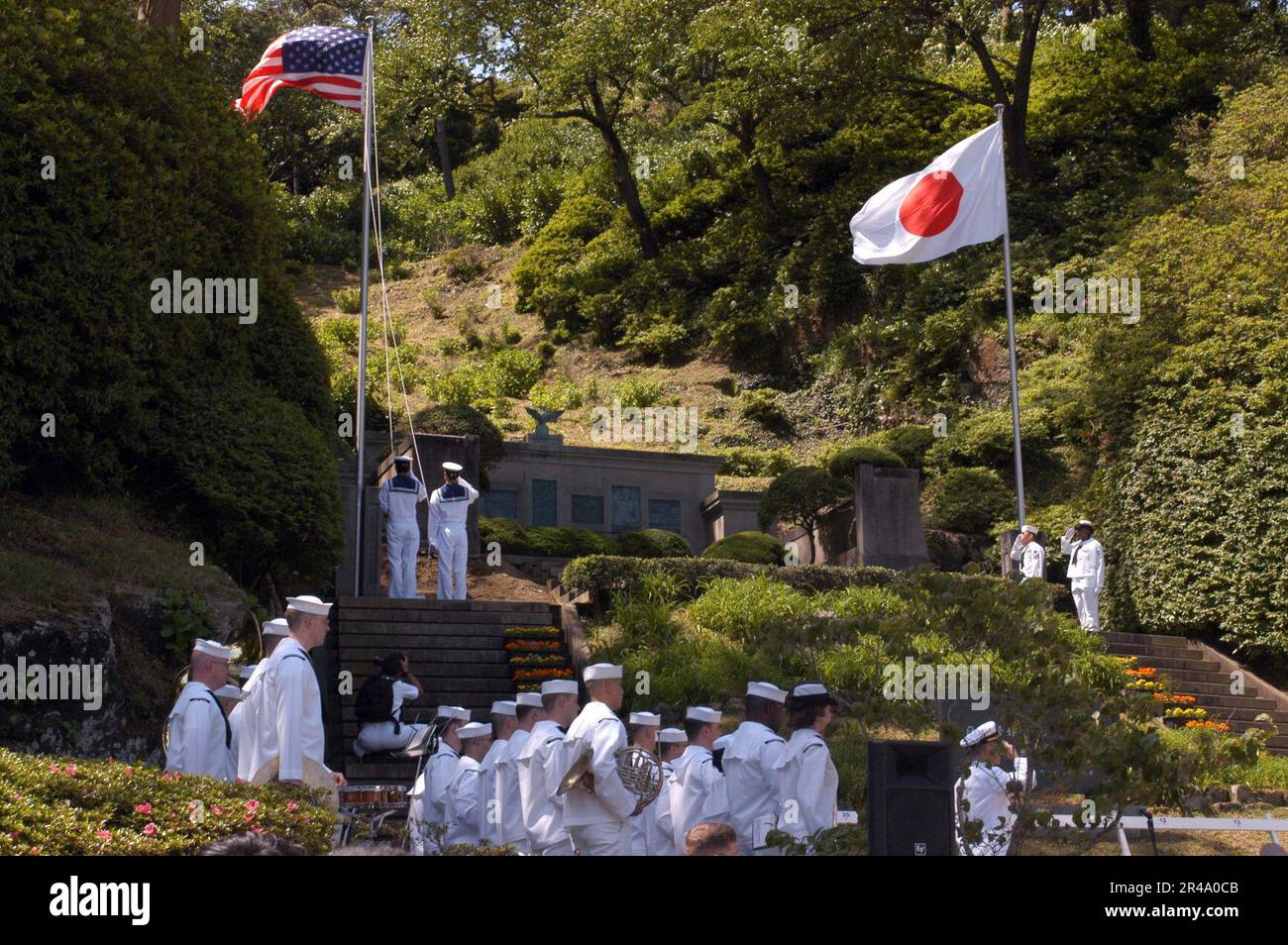 US Navy-Matrosen salutieren von Hand und die USA Die siebte Flottengruppe steht vor der Tür, während Matrosen der japanischen Seeschifffahrtsmacht die Nationalmannschaft erheben Stockfoto