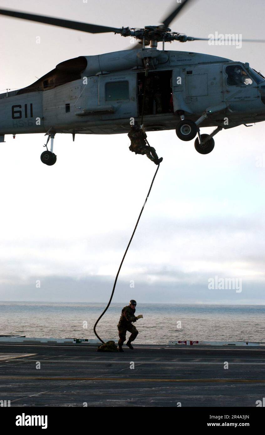 Mitglieder DER US Navy, die der Sprengstoffbeseitigung Mobile Unit Eleven (EODMU-11) zugewiesen sind, verlassen ein SH-60F Seahawk Stockfoto