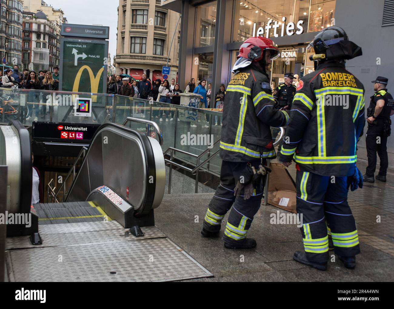 Barcelona, Spanien. 25. Mai 2023. Zwei Feuerwehrleute von Bombers de Barcelona sprechen vor der U-Bahn-Station Universitat, um die Situation zu beurteilen. Gestern um etwa 19:45 Uhr (25. 05. 2023) beging eine Person Selbstmord in der Metrostation Barcelona an der Station Universidat. Ein Mensch warf sich vor den Zug und verursachte den sofortigen Tod. Die Metro-Station Barcelona liefert keine jährlichen Daten über Selbstmorde. Einheiten der Bombers de Barcelona, der SEM (Sistema d'EmergËncies MËdiques) und der Guardia Urbana wurden an den Tatort geschickt. (Foto: Mario Coll/SOPA Images/Sipa USA) Guthaben: SIPA USA/Alamy Live News Stockfoto