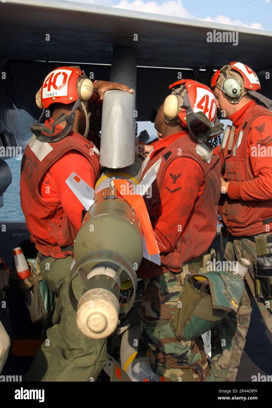 US Navy Aviation Ordnancemen, die den Gunslingers der Streikkämpfer-Staffel eins Null fünf (VFA-105) zugeteilt sind, laden eine 500 kg schwere lasergesteuerte Bombe (GBU-12) auf eine F-A-18 Hornet Stockfoto