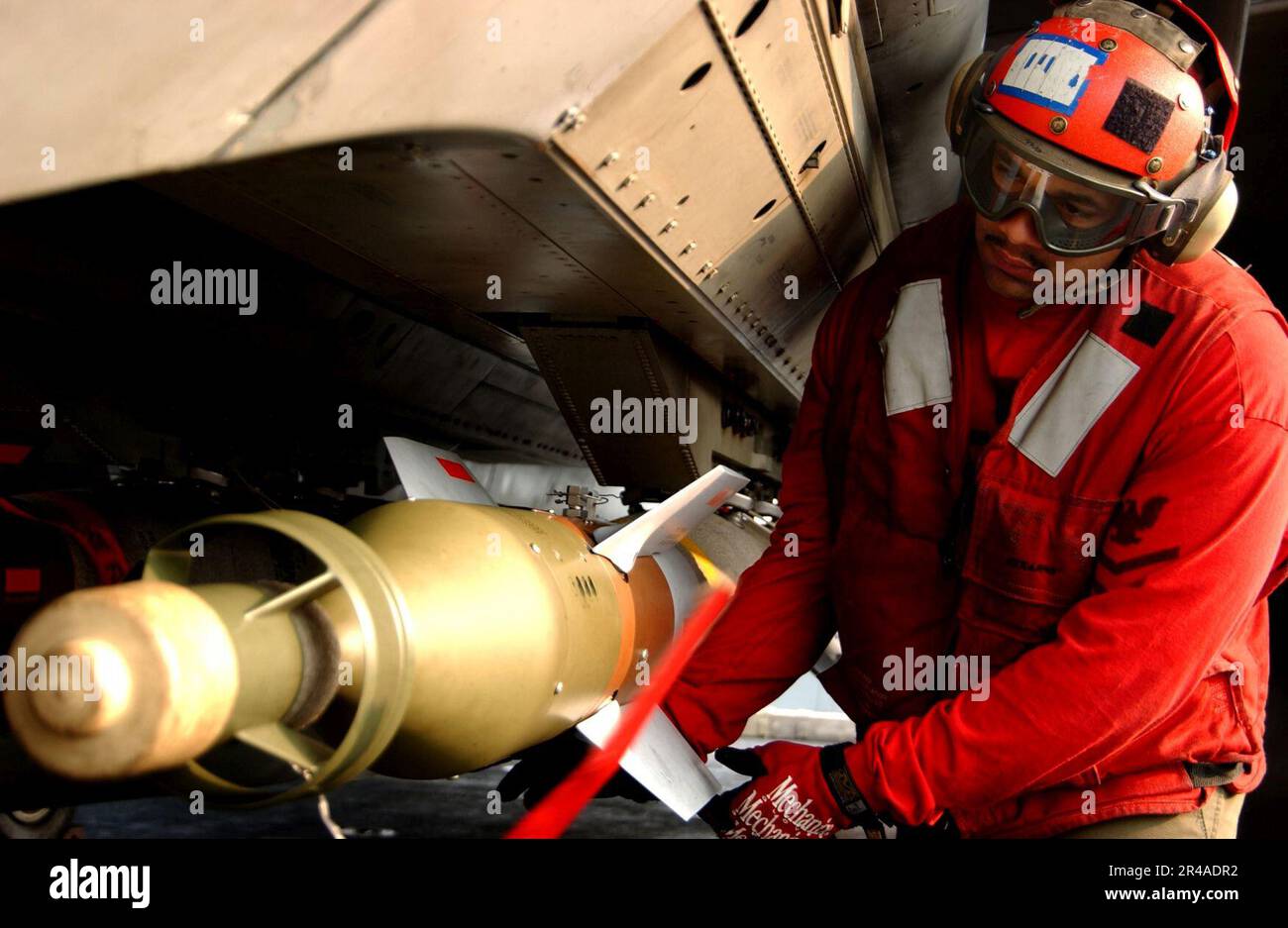 US Navy Aviation Ordnanceman 1. Klasse, die der Schwertkämpferschwadron Three Two (VF-32) zugewiesen ist, stellt sicher, dass eine 500 kg schwere lasergesteuerte Bombe (GBU-12) ordnungsgemäß gesichert ist Stockfoto