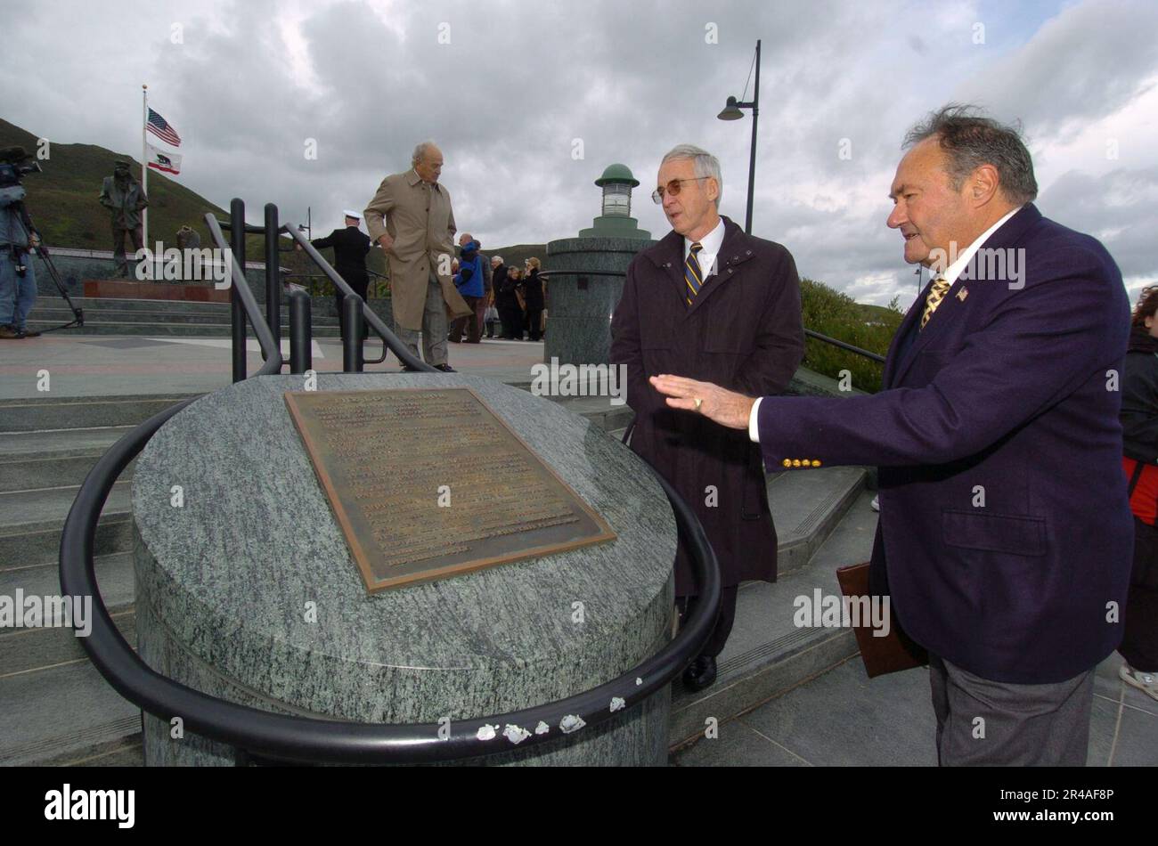 US Navy Secretary of the Navy (SECNAV), Gordon England, bewertet eine Plakette am Lone Sailor Memorial als Jackson Schultz, Right, San Francisco Lone Sailor Memorial offizieller, detailliert die Merkmale der Erinnerungsstücke Stockfoto