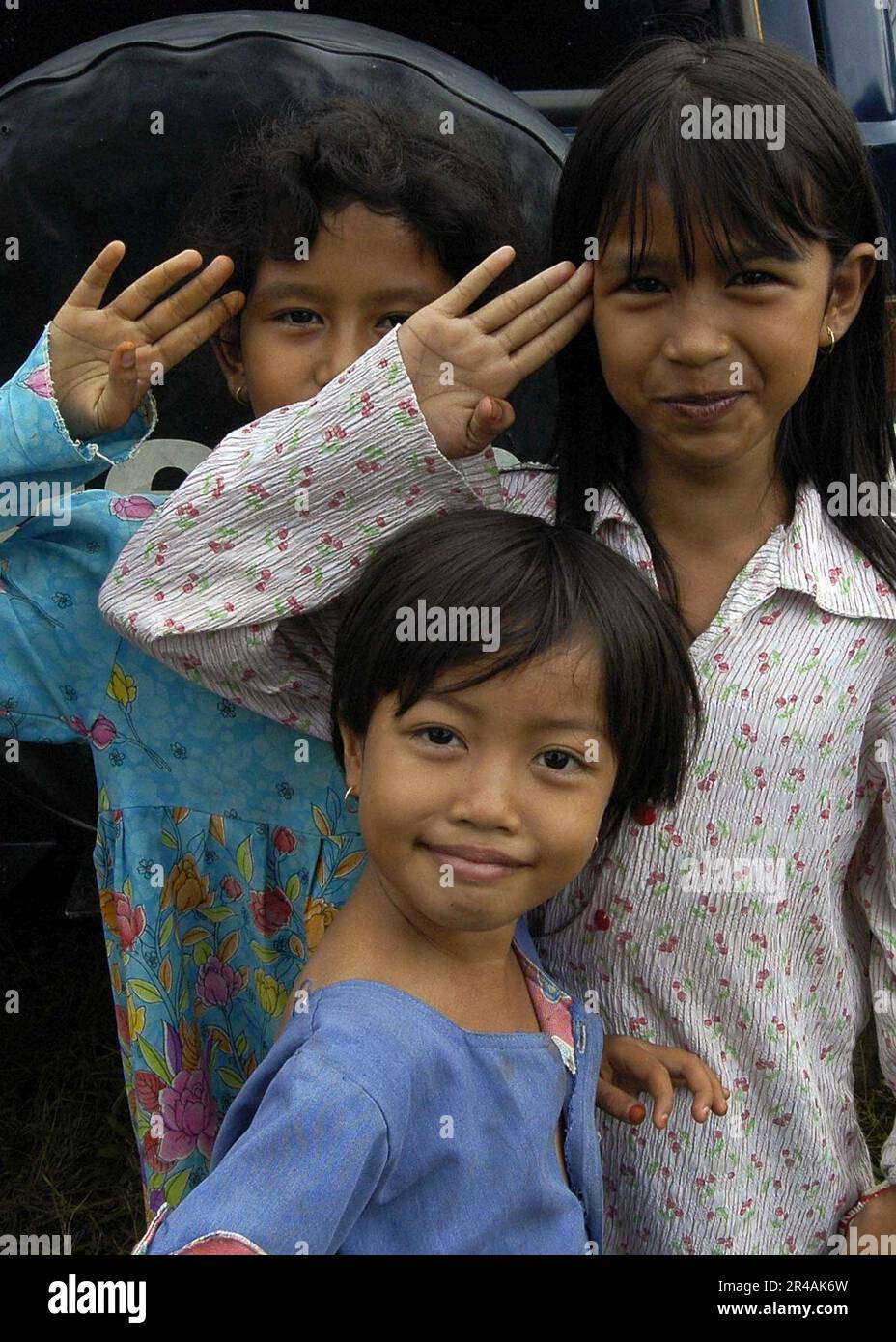 US Navy Young Girls salutieren in ihrer besten Form für ein Foto, das in einem der Lager in der Stadt Alue Bilie, Aceh, für Zivilisten aufgenommen wurde, die durch den Tsunami vom 26. Dezember vertrieben wurden Stockfoto