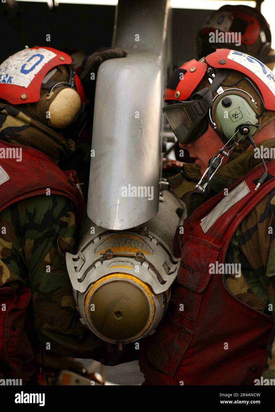 US Navy Aviation Ordnancemen laden eine GBU-38 500 Pfund Satelliten-gesteuerte Bombe auf eine F-A-18A Hornets der Staffel Stockfoto