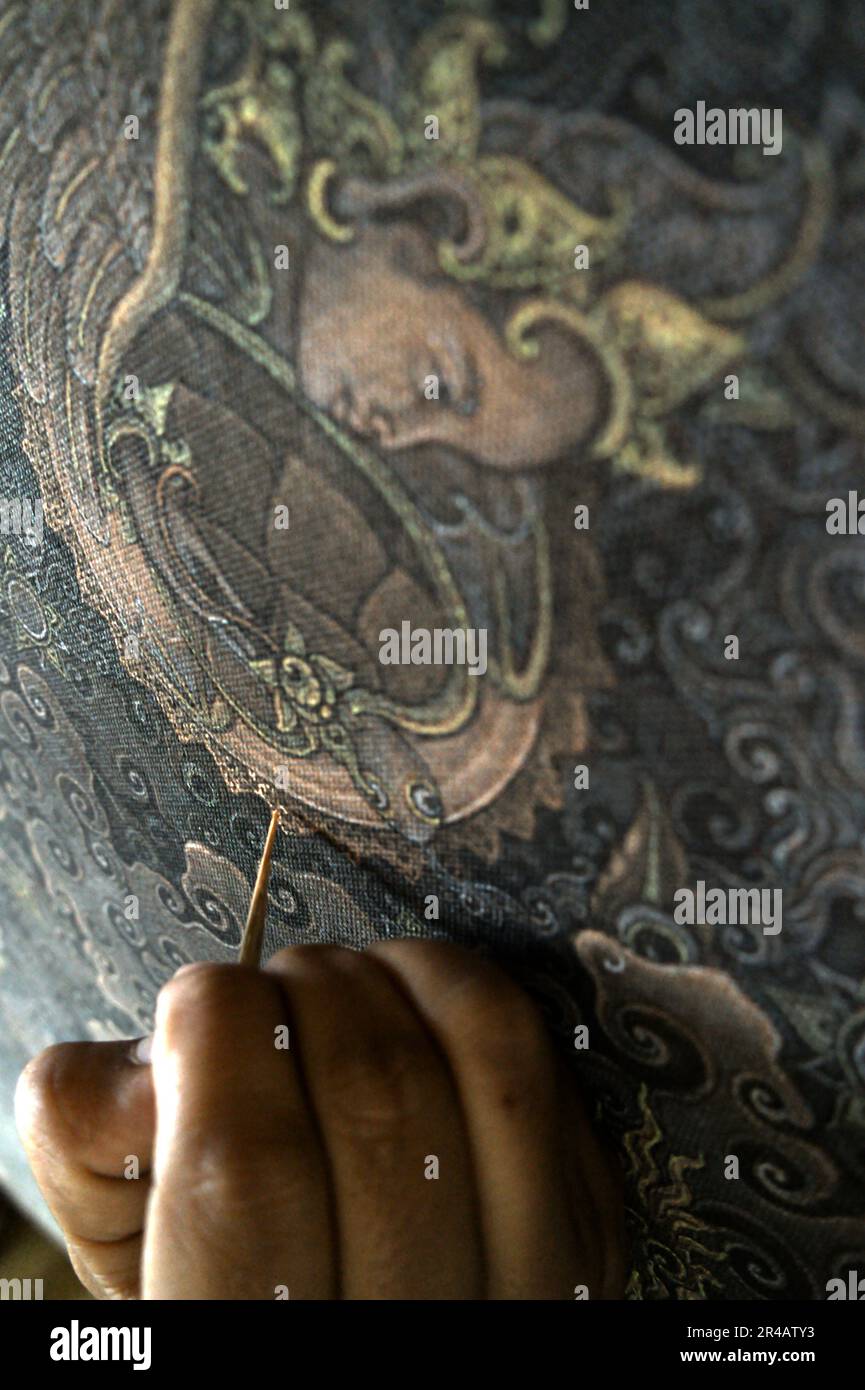 Ein Maler arbeitet an einem Gemälde in Tebesaya (Tebasaya), einem Gebiet, das in der balinesischen Kunstwelt für seine Rolle und seinen Beitrag im „Tebesaya-Malstil“ und in der „Ubud School of painting“ in Ubud, Gianyar, Bali, Indonesien, bekannt ist. Stockfoto