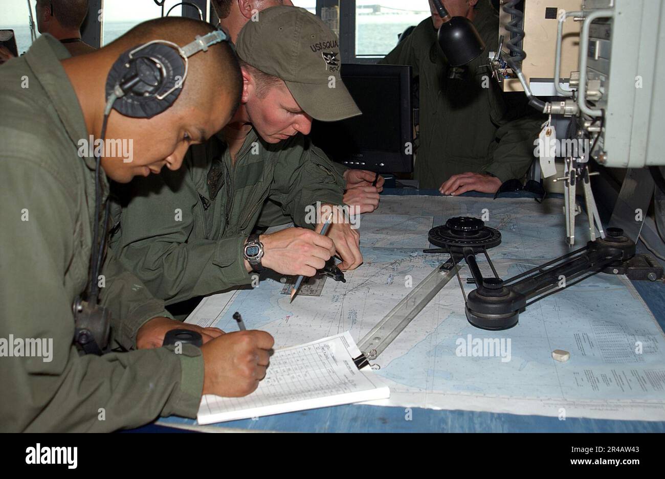 US Navy Quartermaster 2. Class und Quartermaster 2. Class planen einen Kurs, während das Küstenschiff USS Chinook (PC 9) der Cyclone-Klasse den Persischen Golf durchquert. Stockfoto