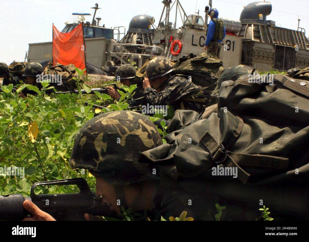 US Navy Philippine Marines nehmen Verteidigungspositionen ein, nachdem sie die USA verlassen haben Navy Landing Craft, Luftkissen (LCAC) während eines Amphibien-Übungstrainings. Stockfoto