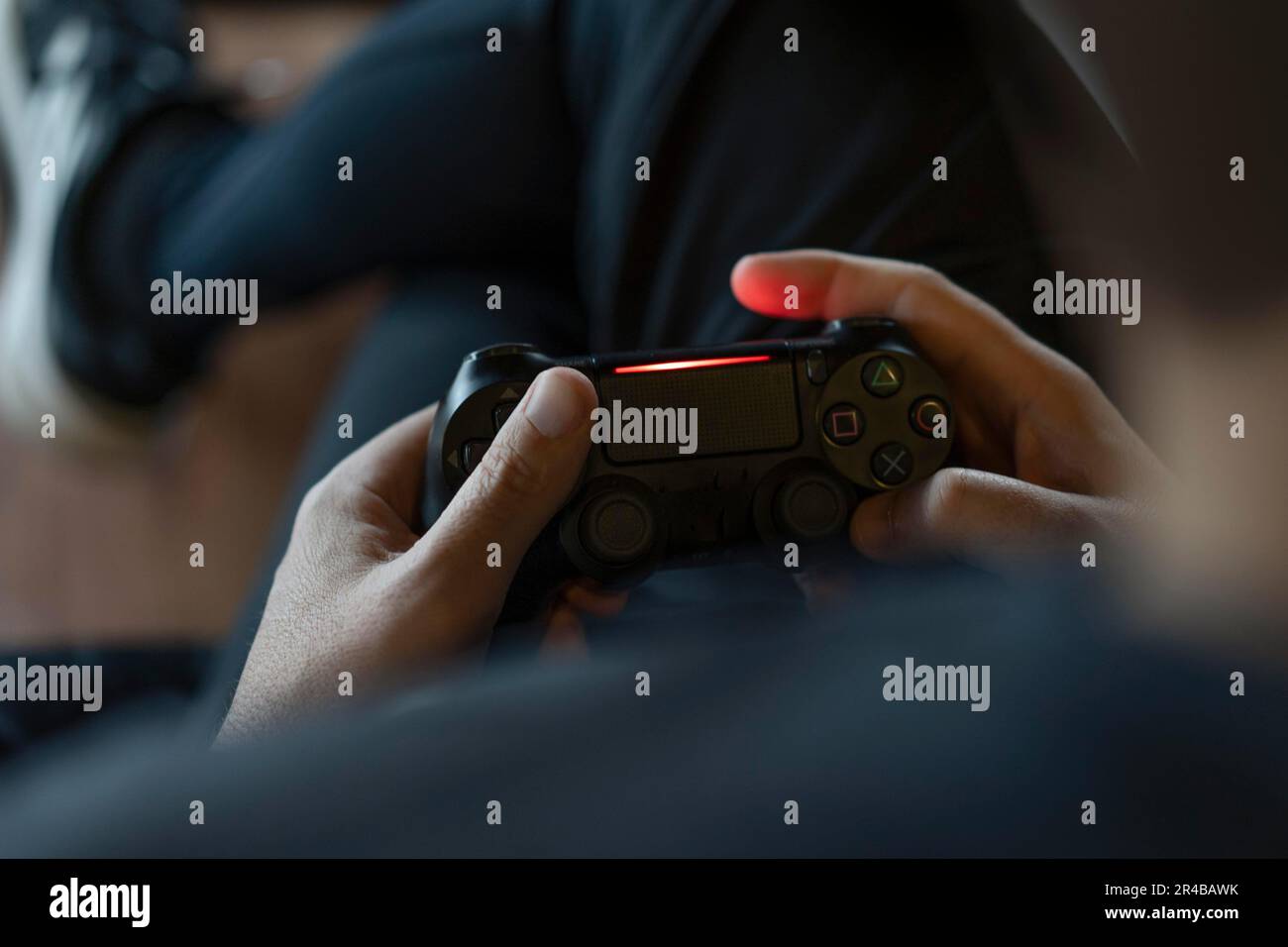 Nahaufnahme der Hände eines erwachsenen Mannes, der einen Joystick hält, während er ein Videospiel auf einer Konsole spielt Stockfoto
