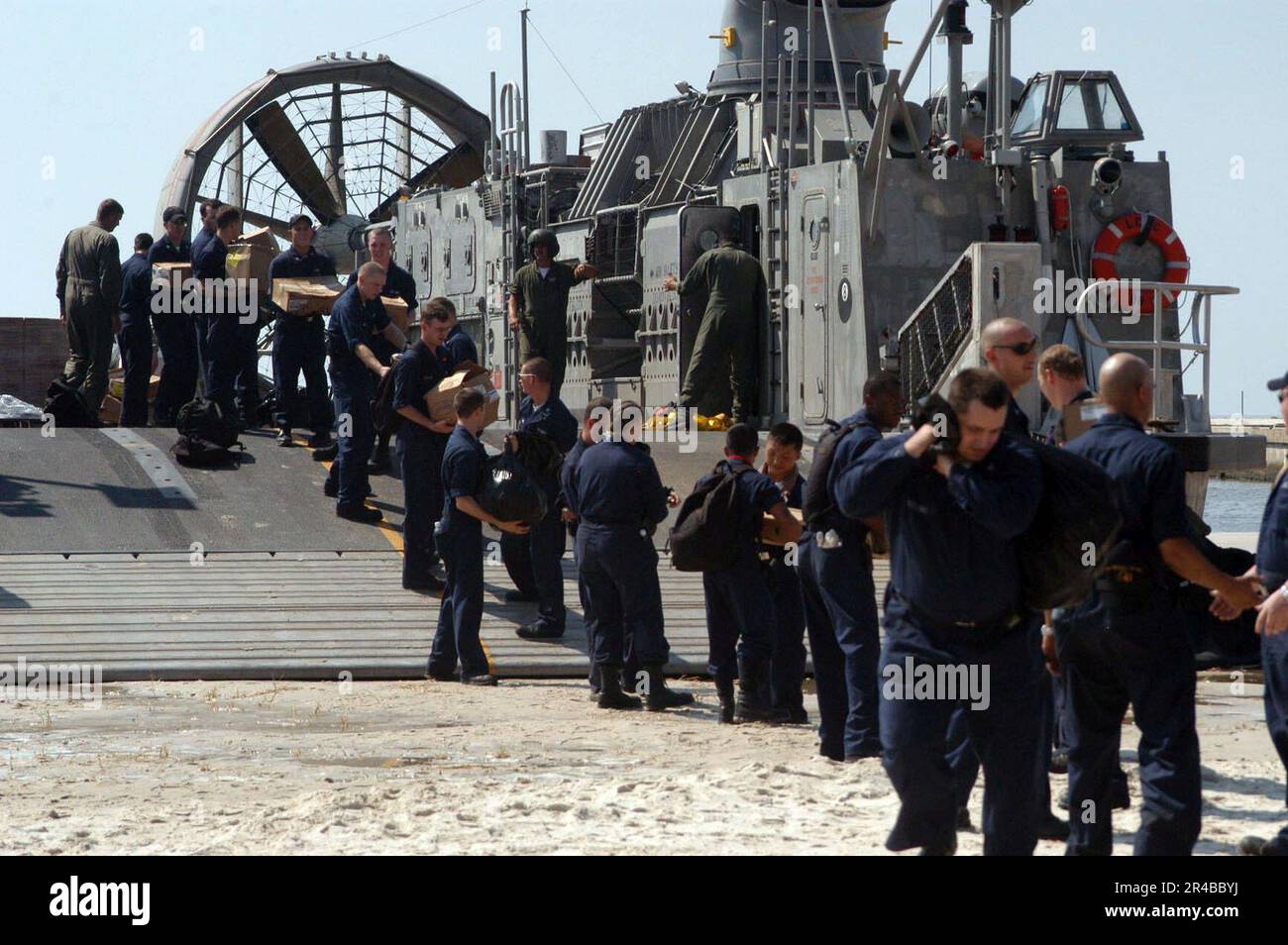 US Navy USA Marinesoldaten, die dem Amphibien-Dock-Landungsschiff USS Whidbey Island (LSD 41) zugeteilt sind, entladen Vorräte, die von einem Landungsschiff, Air Cushion (LCAC), an Land gebracht werden. Stockfoto