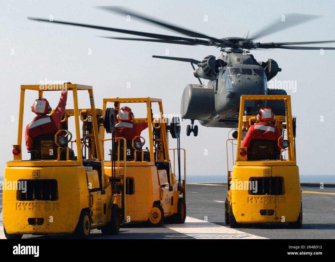 US Navy-Matrosen, die Gabelstapler besetzen, bereiten sich darauf vor, Vorräte in einen MH-53 Sea Dragon Helikopter auf dem Flugdeck an Bord der USS Harry S. Truman (CVN 75) zur Unterstützung der Hurrikanhilfe zu laden. Stockfoto
