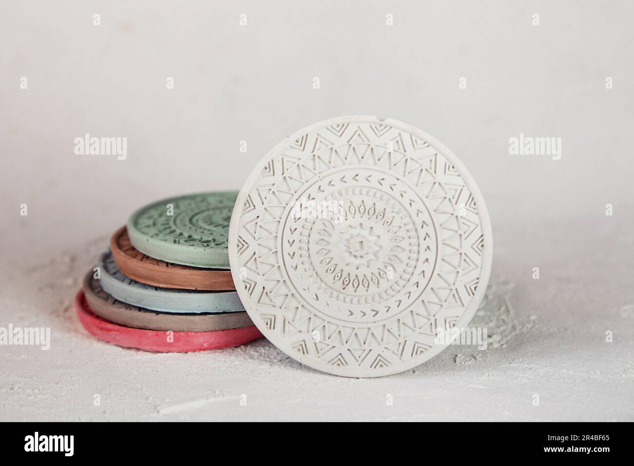 Beton Färben. Weiße Mandala-Untersetzer. Handuntersetzer. Kerzenhalter, Dekorative Teile. Betonuntersetzer Stockfoto