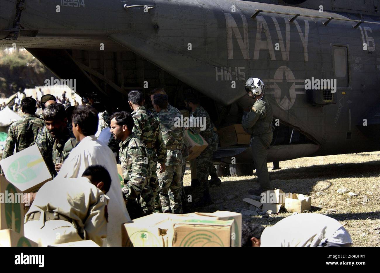 US Navy pakistanische Soldaten entladen Katastrophenvorräte aus den USA Navy MH-53 Sea Dragon Hubschrauber in Balakot, Pakistan. Stockfoto