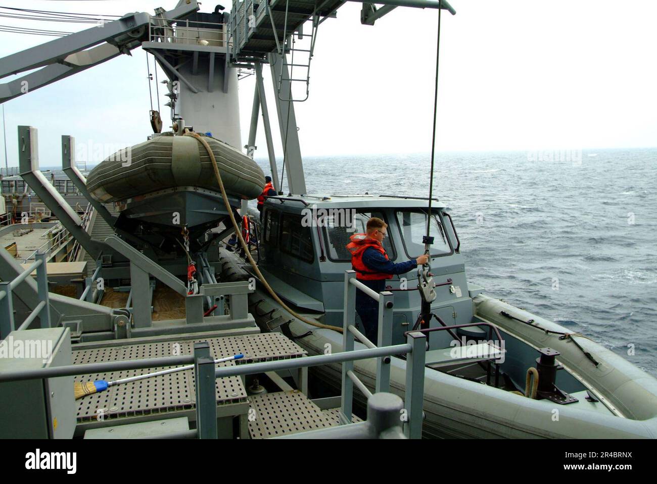 DER US Navy Seaman bemannt den Bogenhaar auf einem der neuen RHIB-Boote (Rigid Hull Inflatable Boats) des Schiffs an Bord der Amphibien-Anlegestelle USS Harpers Ferry (LSD 49). Stockfoto