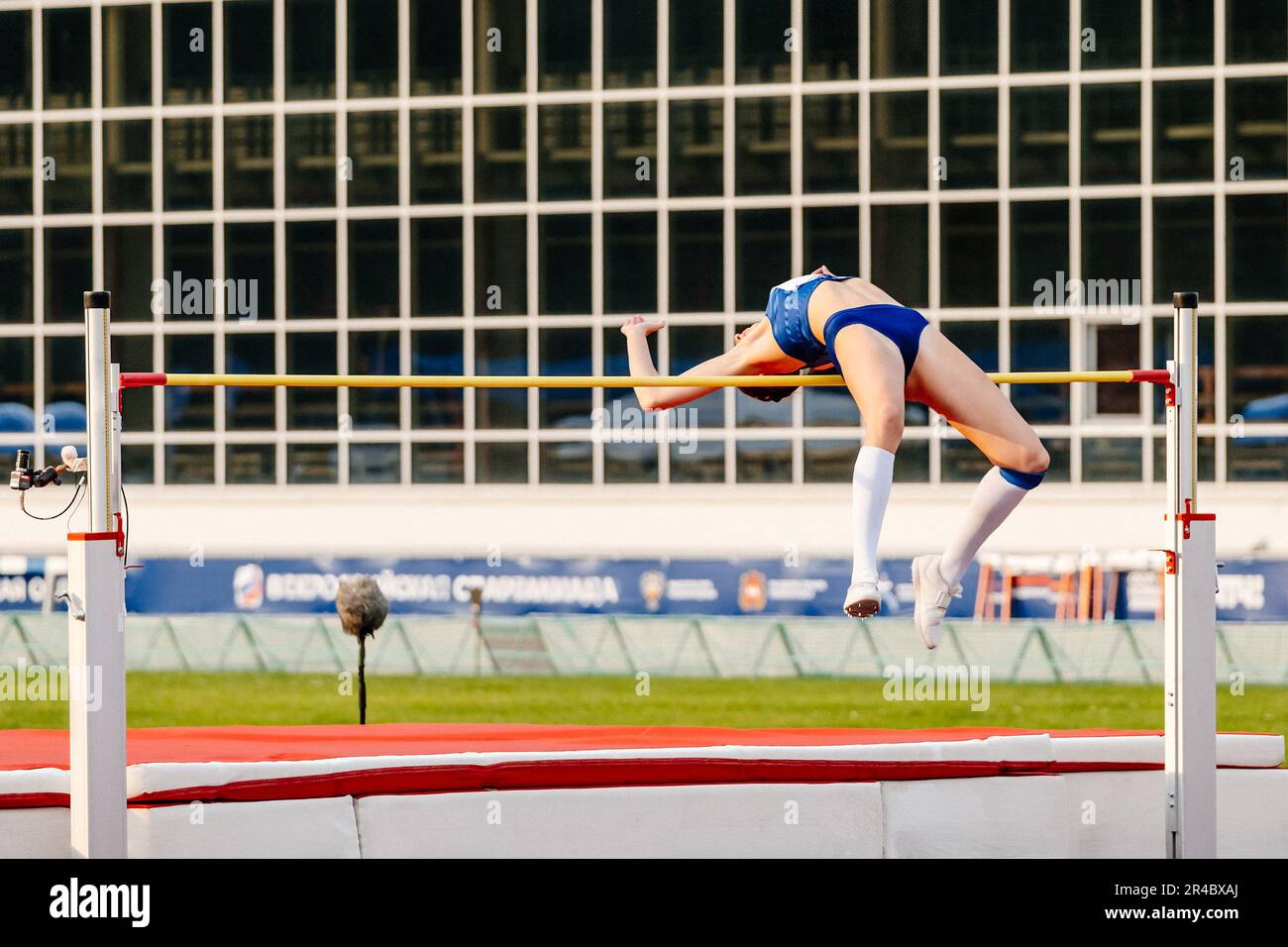 Eine Sportlerin, die in den Sommermeisterschaften der Leichtathletik, fosbury Flop Technique, über die Bretter springt Stockfoto