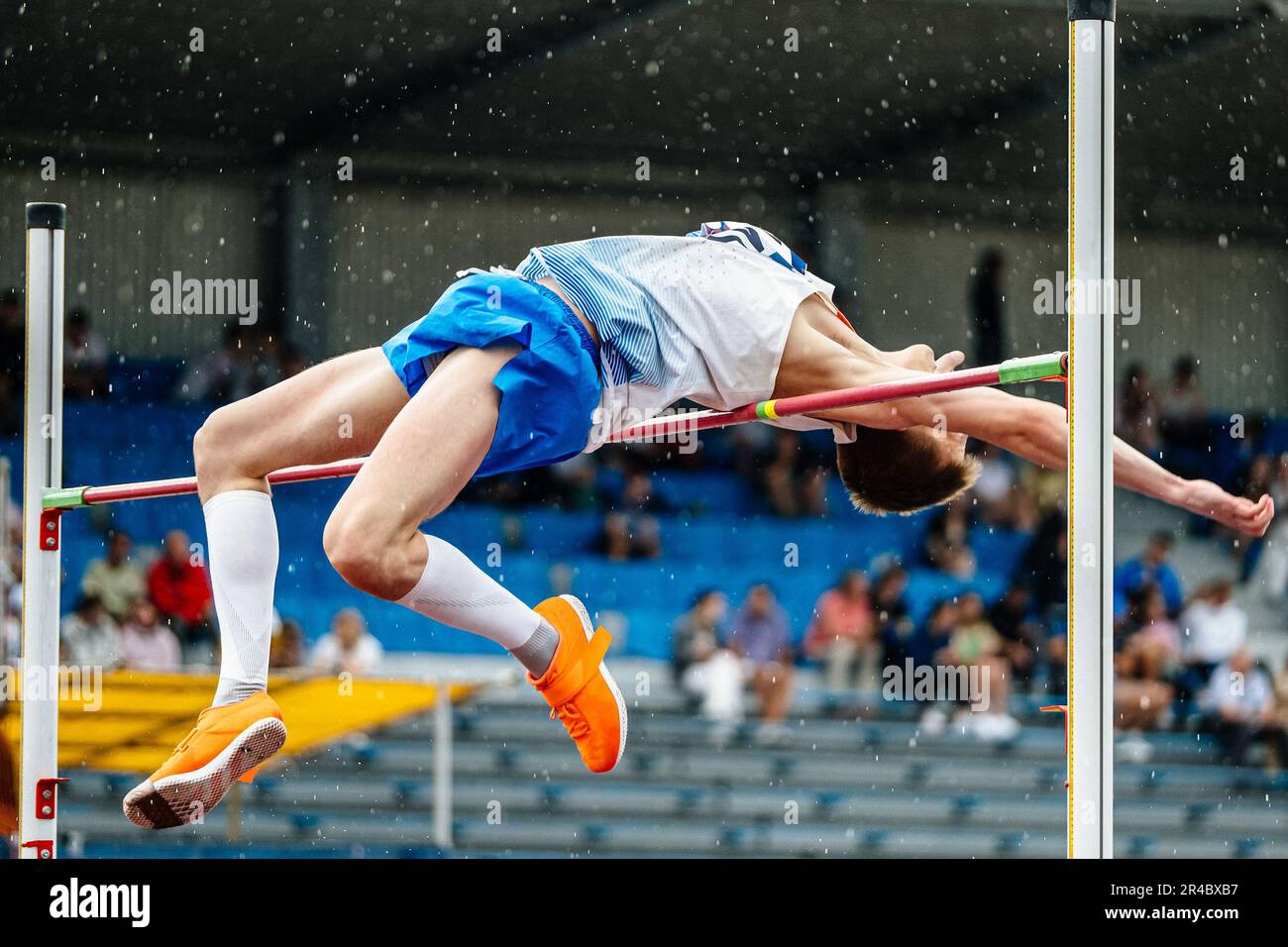 Nahaufnahme Mann-Athlet High-Jump im Regen, Sommer-Athletik-Meisterschaften, fosbury-Flop-Technik Stockfoto