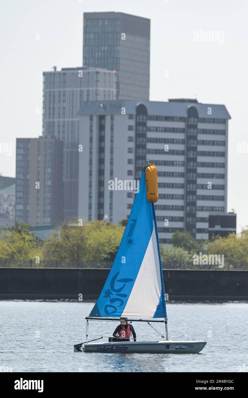 Edgbaston Reservoir, Birmingham, 27. Mai 2023 - leidenschaftliche Wassersportbegeisterte gingen am Samstagmorgen zum Edgbaston Reservoir, um die heißen Temperaturen am Spring Bank Holiday Weekend zu genießen. Mehrere Sonnenanbeter benutzten Segel- und Ruderboote, um das glitzernde Wasser zu durchqueren, während Birminghams Skyline im Hintergrund auftauchte. Ein Windsurfer nutzte auch den kleinen Wind, um Spaß in der Sonne zu haben. Kredit: Stop Press Media/Alamy Live News Stockfoto