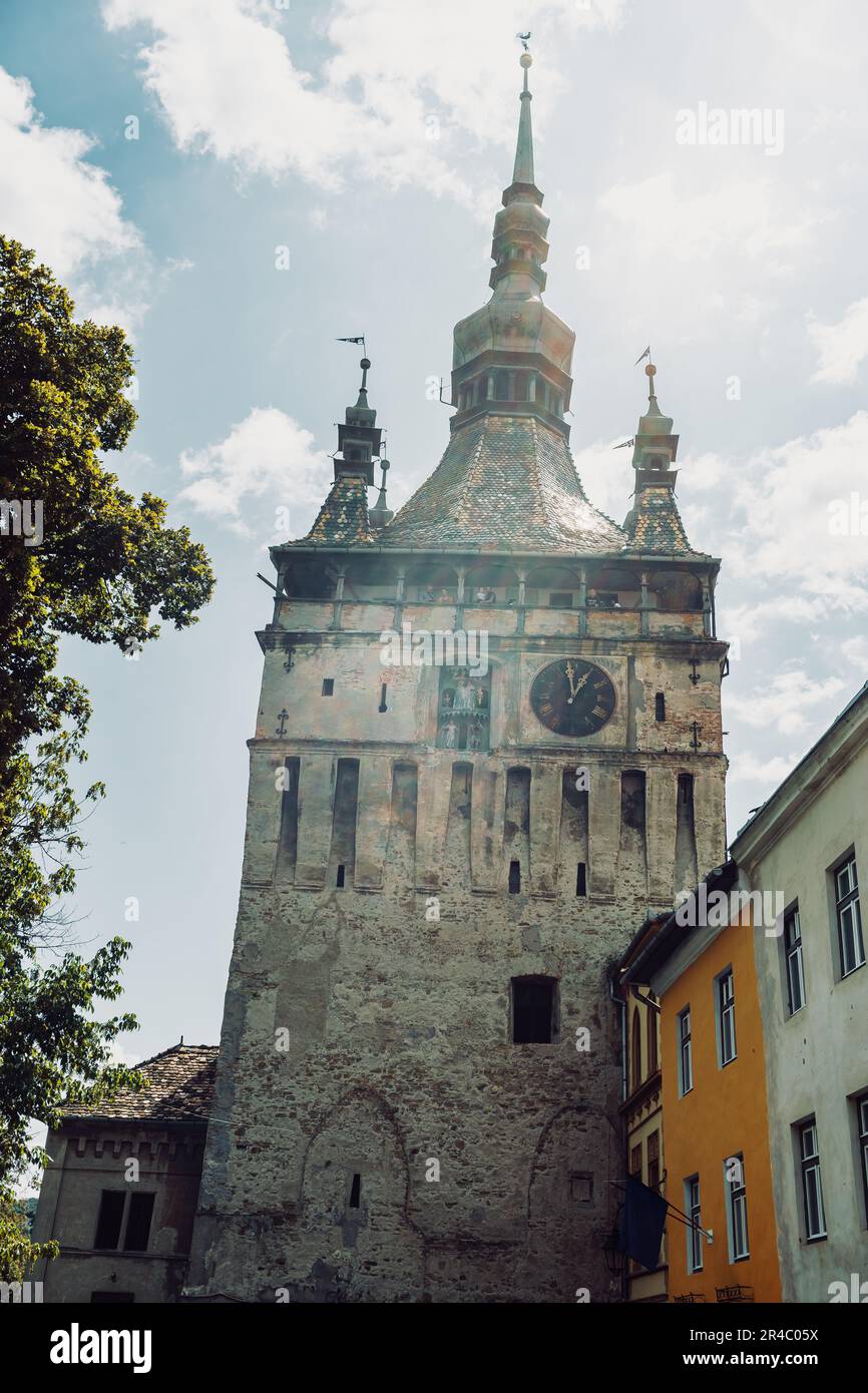 Eine imposante Ziegelstruktur mit mehreren Fenstern und einem auffälligen Turm an der Seite Stockfoto