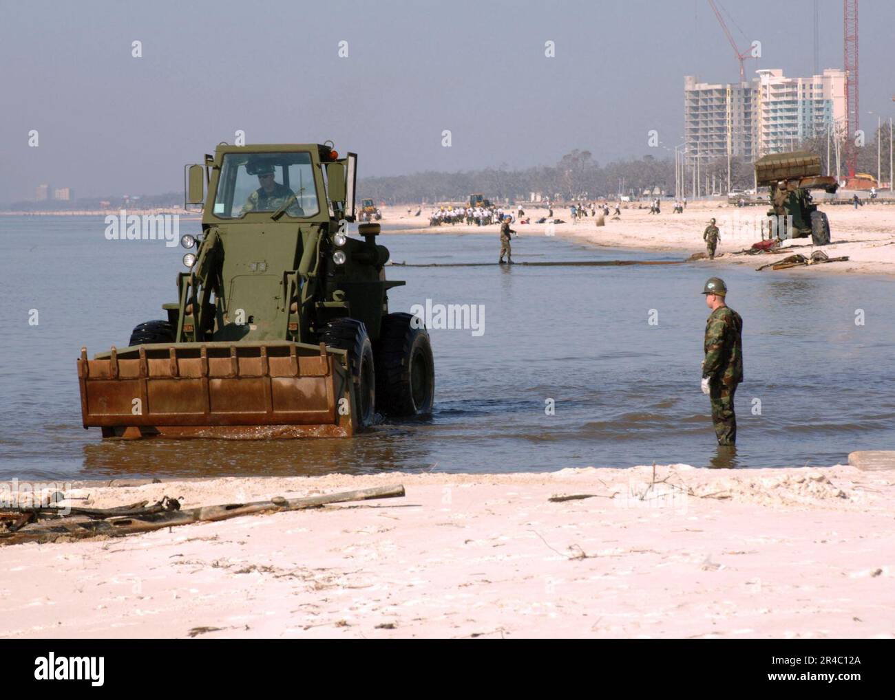 Mitarbeiter DER US Navy, die dem Naval Mobile Construction Battalion Seven Four (NMCB-74) zugeteilt sind, verwenden Frontlader, um im Sand entlang der Küste des Golfs von Mexiko vergrabene Trümmer zu beseitigen. Stockfoto