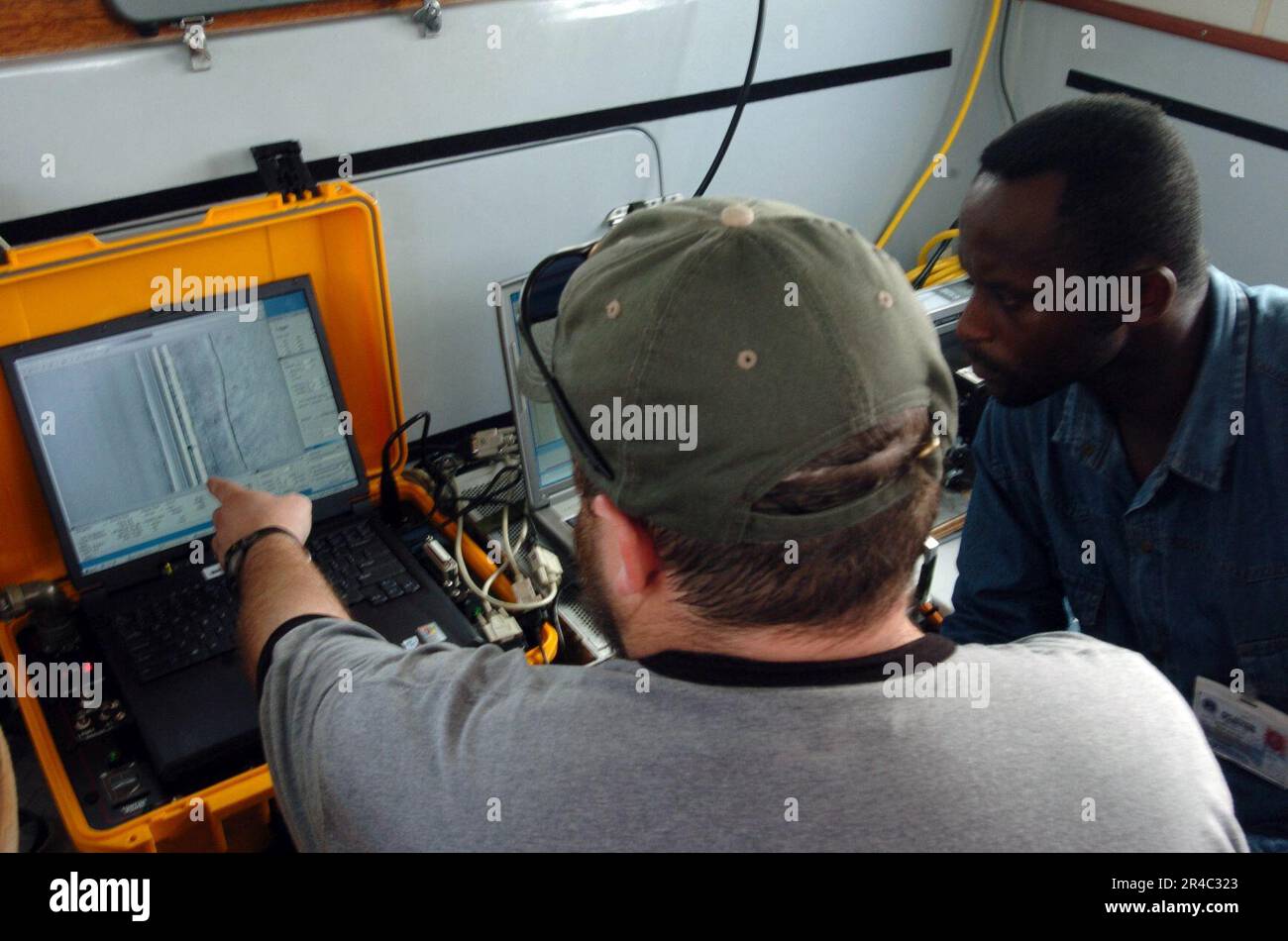 DER verantwortliche US Navy-Hydrograf zeigt seinem kongolesischen Pendant die mit hydrografischen Untersuchungsgeräten aufgezeichneten Informationen. Stockfoto