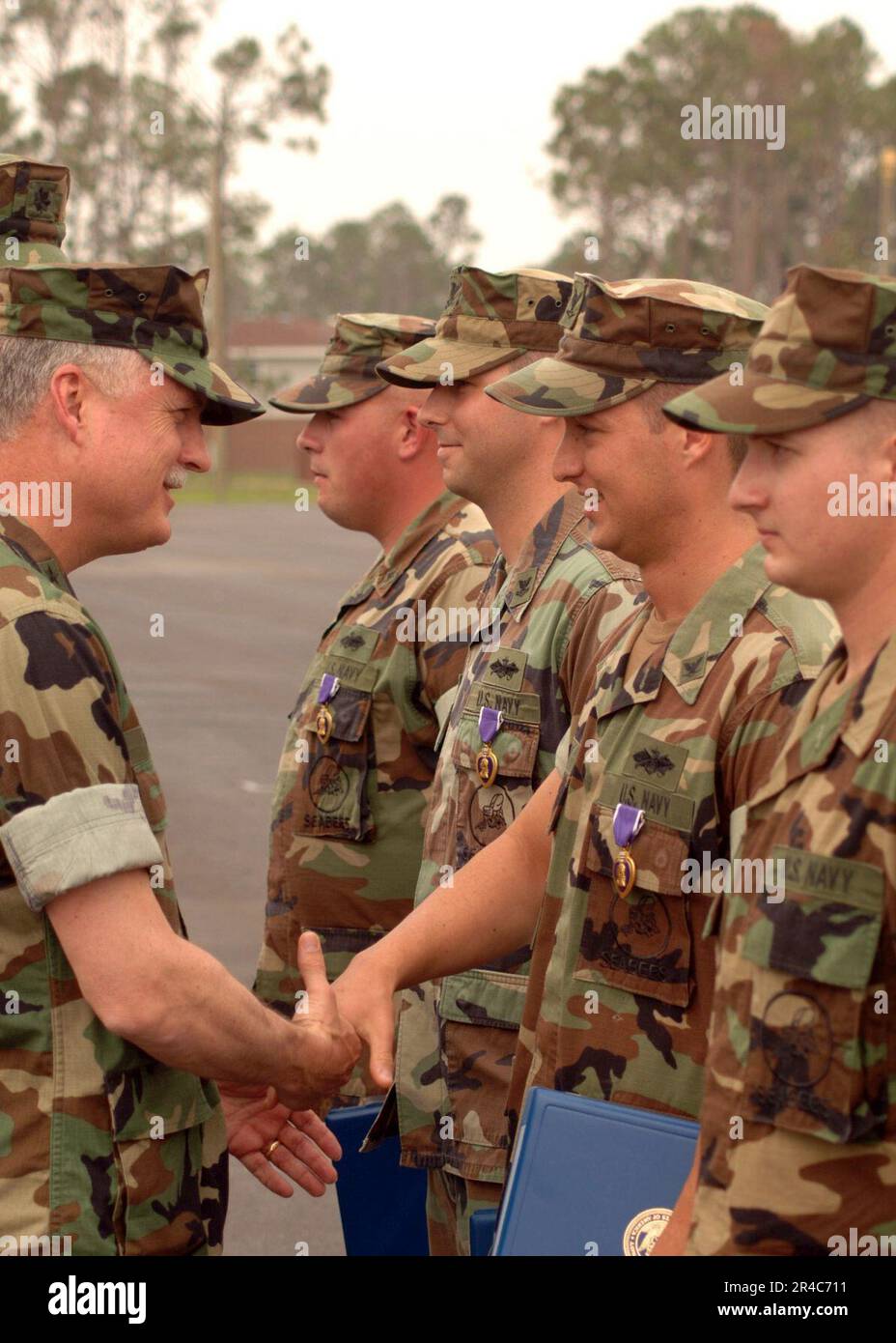 US Navy Commander, First Naval Construction Division, Rear ADM Robert L. Phillips präsentiert Petty Officer 3. Klasse mit dem Purple Heart. Stockfoto