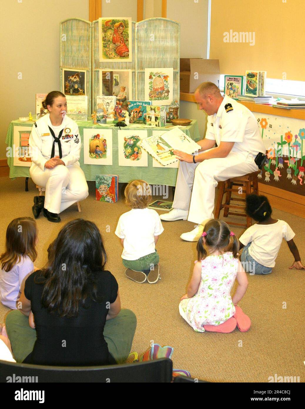 US Navy Sailers aus dem Navy Recruiting District (NRD) Nashville lesen während der Navy Week Little Rock im Jugendarbeitsministerium der Arkansas Main Library Geschichten und singen Lieder für Kinder. Stockfoto