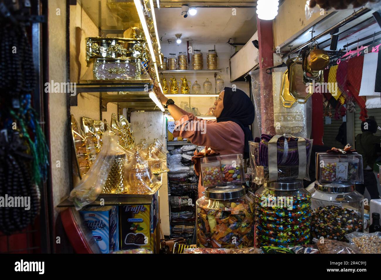 Bandung, West Java, Indonesien. 27. Mai 2023. Händler bereiten Bestellungen in einem Vertriebszentrum für haj-Souvenirs in Pasar Baru, Bandung, West Java, Indonesien, vor. Händler gaben an, dass Händler im Vertriebszentrum für Souvenirs von Hajj und Umrah bei Pasar Baru Bandung in diesem Jahr ihre Umsätze um durchschnittlich 80 Prozent oder rund 10 Millionen Rupiah auf 30 Millionen Rupiah pro Tag im Vergleich zum Vorjahr erhöht hatten. Kredit: Dimas Rachmatsyah/Alamy Live News Stockfoto