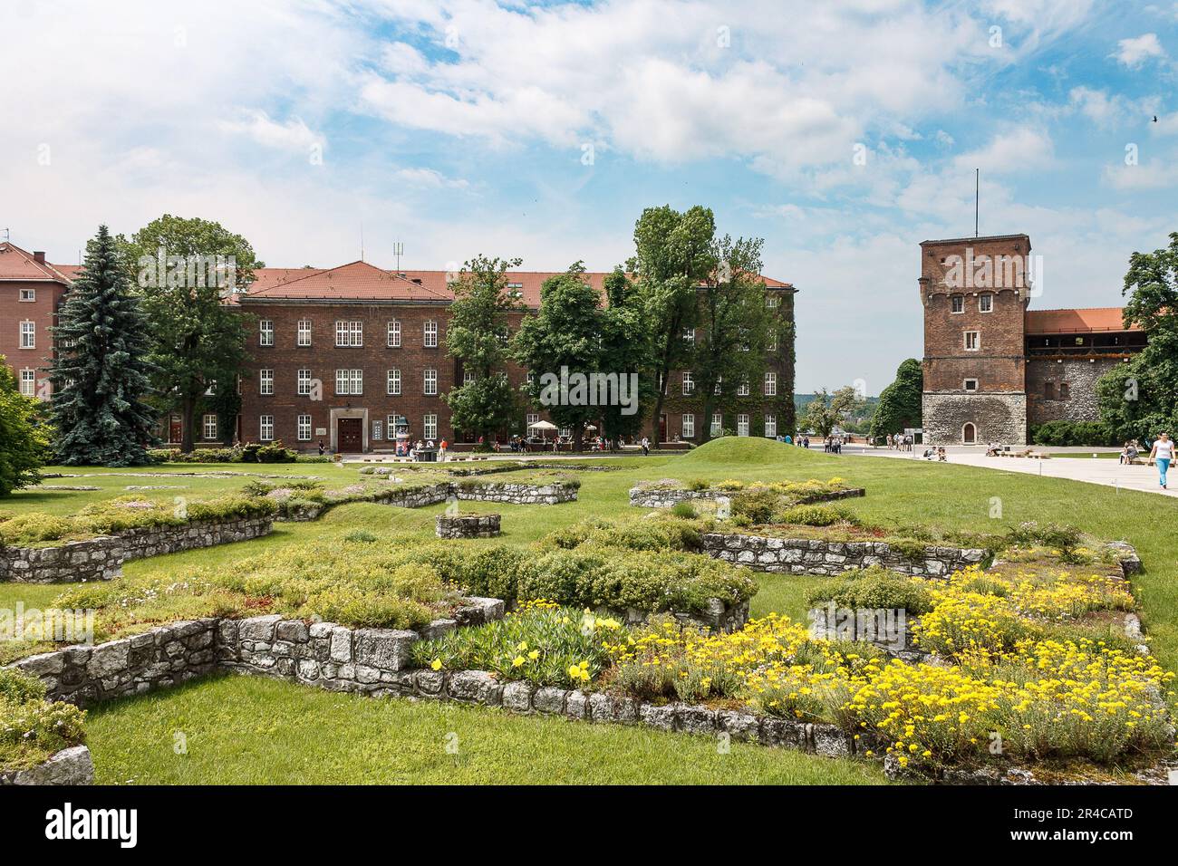 Ein klassisches architektonisches Gebäude, umgeben von üppigen grünen Gärten und einem kopfsteingepflasterten Pfad, der die beiden Strukturen verbindet Stockfoto