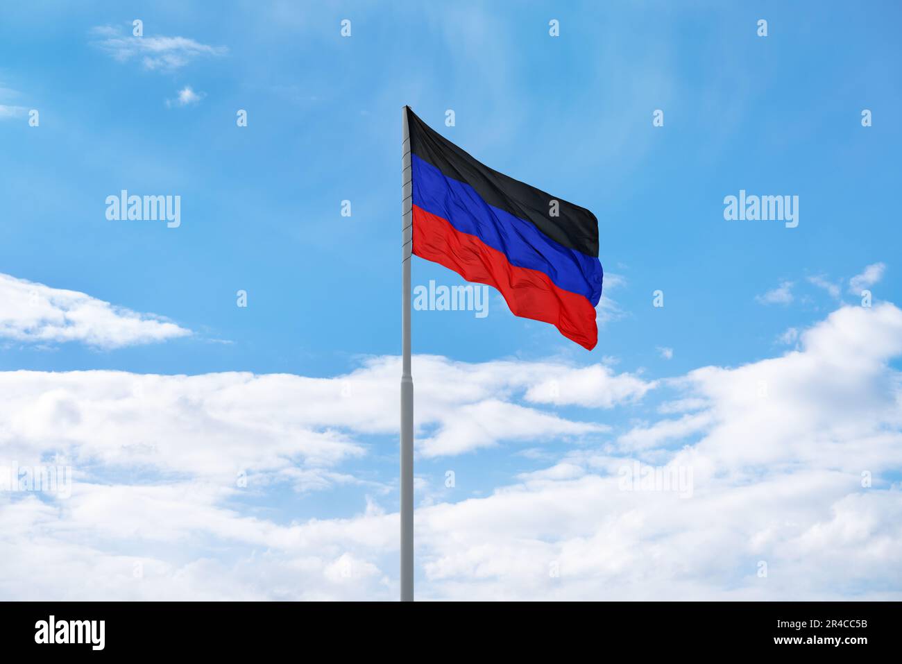 Die Flagge der selbst proklamierten Volksrepublik Donezk (DPR oder DNR) winkt vor blauem Himmel und Wolken Stockfoto