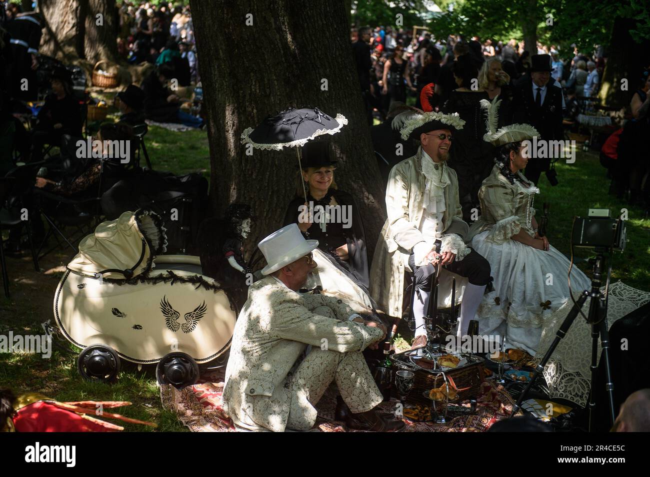 Die Teilnehmer nehmen am viktorianischen Picknick im Stadtpark Leipzig Teil. Das viktorianische Picknick findet jedes Jahr im Rahmen der Wave Gotik Treffen statt, dem jährlichen Weltfestival für „Darkmusik“ und „Darkkultur“. Traditionell treffen sich am Freitagnachmittag vor dem Pfingsten Tausende von Fans der gotischen Szene zu einem großen Picknick im Clara Zetkin Park in Leipzig und feiern gemeinsam den Beginn des Festivals, das dieses Jahr zum 30. Mal stattfindet. Viele der Festivalbesucher kleiden sich für das Picknick in prächtigen Kostümen vom Barock bis zum Rokoko, manchmal gemischt mit fantastischen Elementen und Stockfoto