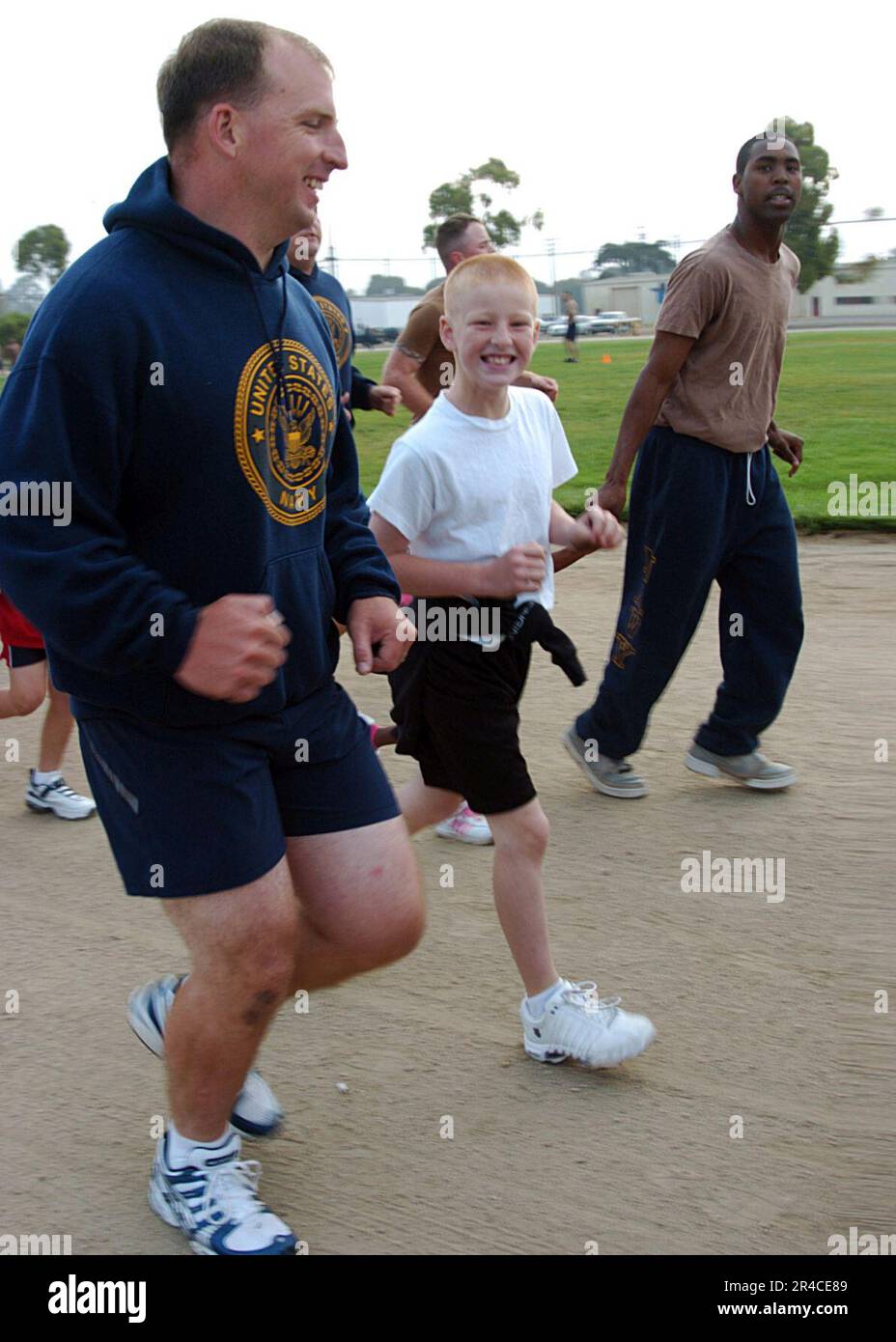 US Navy Equipment Operator 1. Klasse zugewiesen zum Naval Mobile Construction Battalion 4 (NMCB-4) und seinem Sohn, halten Sie Schritt während eines Familienbildungslaufs Stockfoto