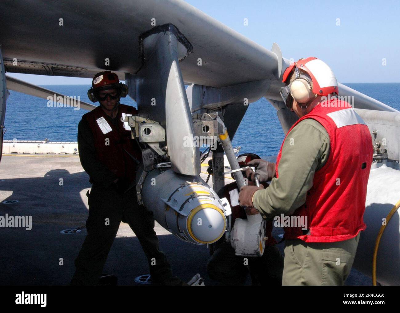 MARINES der US-Marine, die der Marine-Angriffsschwadron Three One (VMA-311) zugeteilt sind, laden eine GBU-38 Joint Attack Direct Munition auf den Flügel eines AV-8B Harrier. Stockfoto