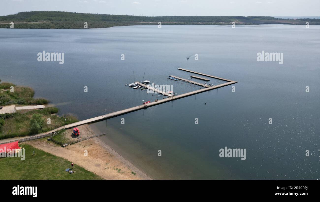 Aschersleben, Deutschland. 27. Mai 2023. Blick auf die Anlegestelle am Lake Concordia (mit Drohne aufgenommen). Die Badesaison am Lake Concordia beginnt. Aufgrund eines Erdrutsches im Jahr 2009 wurde der größte künstliche See im Harzer Vorland in Sachsen-Anhalt seit vielen Jahren vollständig geschlossen und ist auch heute noch teilweise geschlossen. Der Concordia See für Touristen ist seit 13.07.2019 wieder geöffnet. Kredit: Matthias Bein/dpa/Alamy Live News Stockfoto