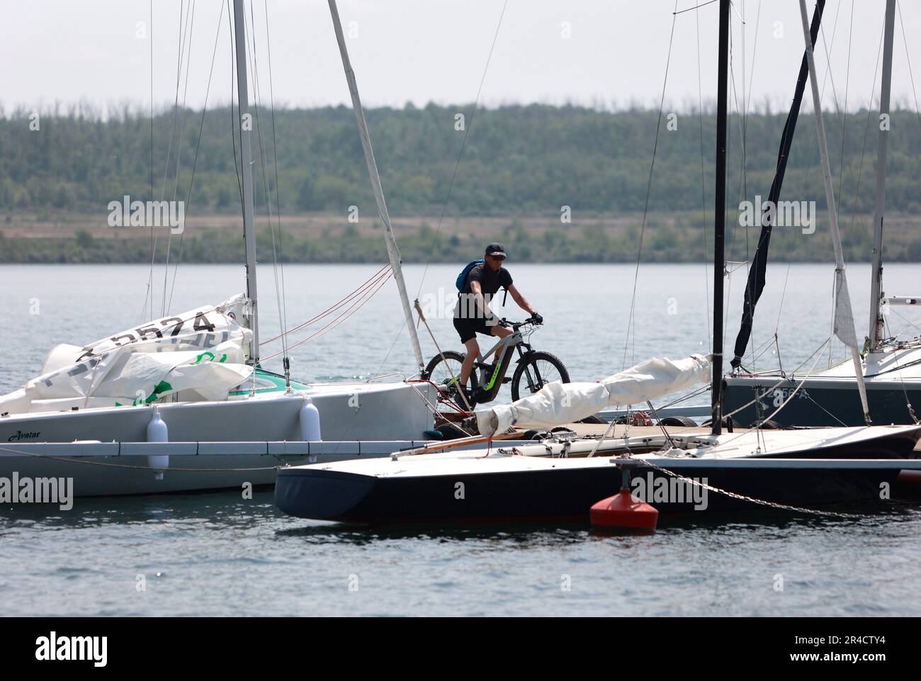 Aschersleben, Deutschland. 27. Mai 2023. Ein Badender fährt mit dem Fahrrad auf einem Dock am Concordia-See. Die Badesaison am Lake Concordia beginnt. Aufgrund eines Erdrutsches im Jahr 2009 war der größte künstliche See in den Ausläufern von Harz in Sachsen-Anhalt viele Jahre alt und ist noch teilweise geschlossen. Der Concordia See für Touristen ist seit 13.07.2019 wieder geöffnet. Kredit: Matthias Bein/dpa/Alamy Live News Stockfoto