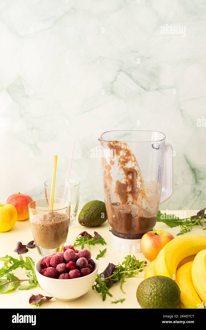 Gesundes Frühstück, gesunder, köstlicher Smoothie mit gefrorenen Kirschen und Bananen und Avocado, Erbsenprotein und gemischten Grüns, Mixer für Smoothie-Gläser Stockfoto