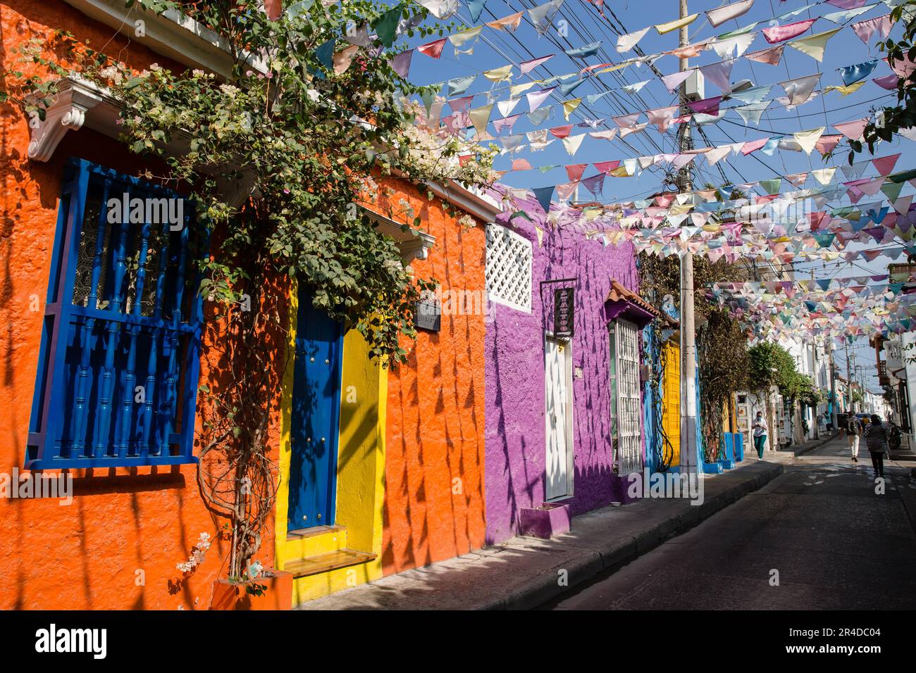 Blick auf eine Straße mit Wimpelflaggen, die über farbenfrohe Gebäude in Cartagena Colombia hängen Stockfoto